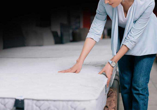 Woman looking at mattress in Australian mattress store, wondering how to judge value in a mattress