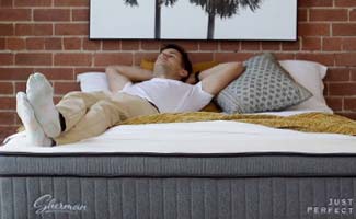 Young man tries out Sherman mattress in Melbourne showroom